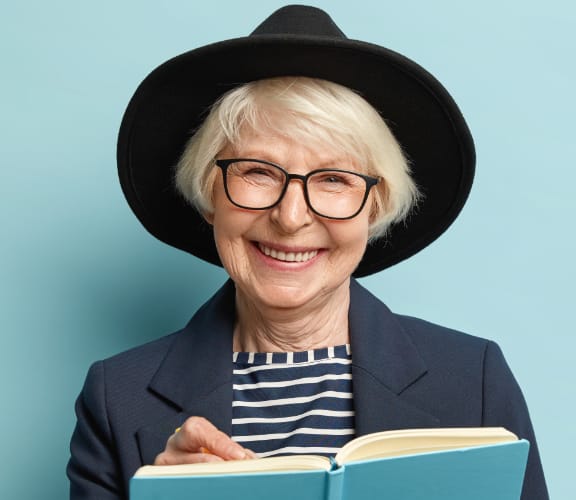 Mature woman with a nice hat reading a book